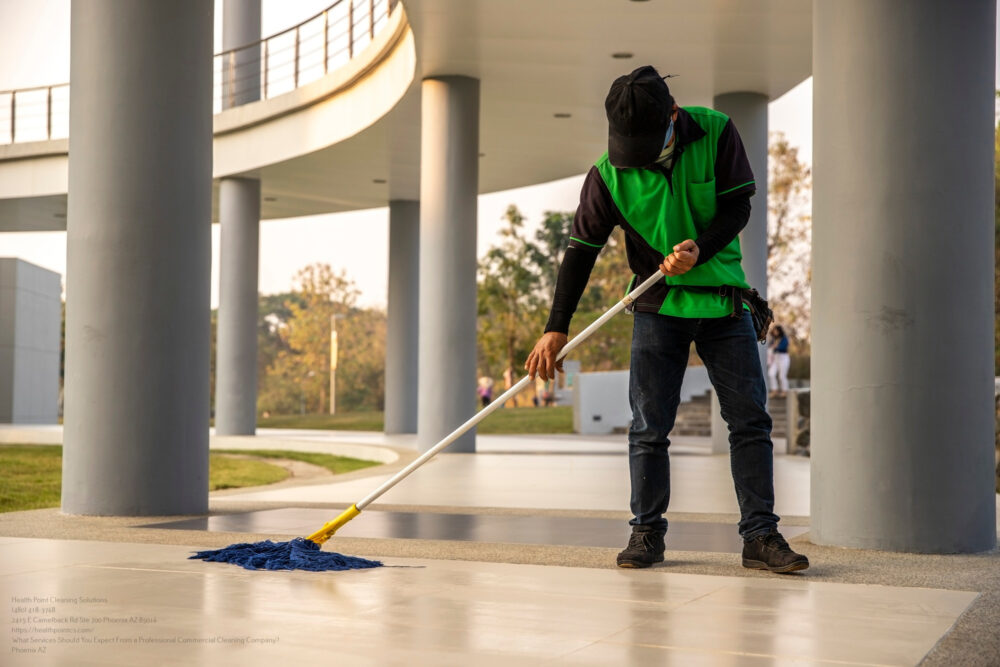 A Janitor Man Cleaning Mopping Floor In Office Building Or Wa